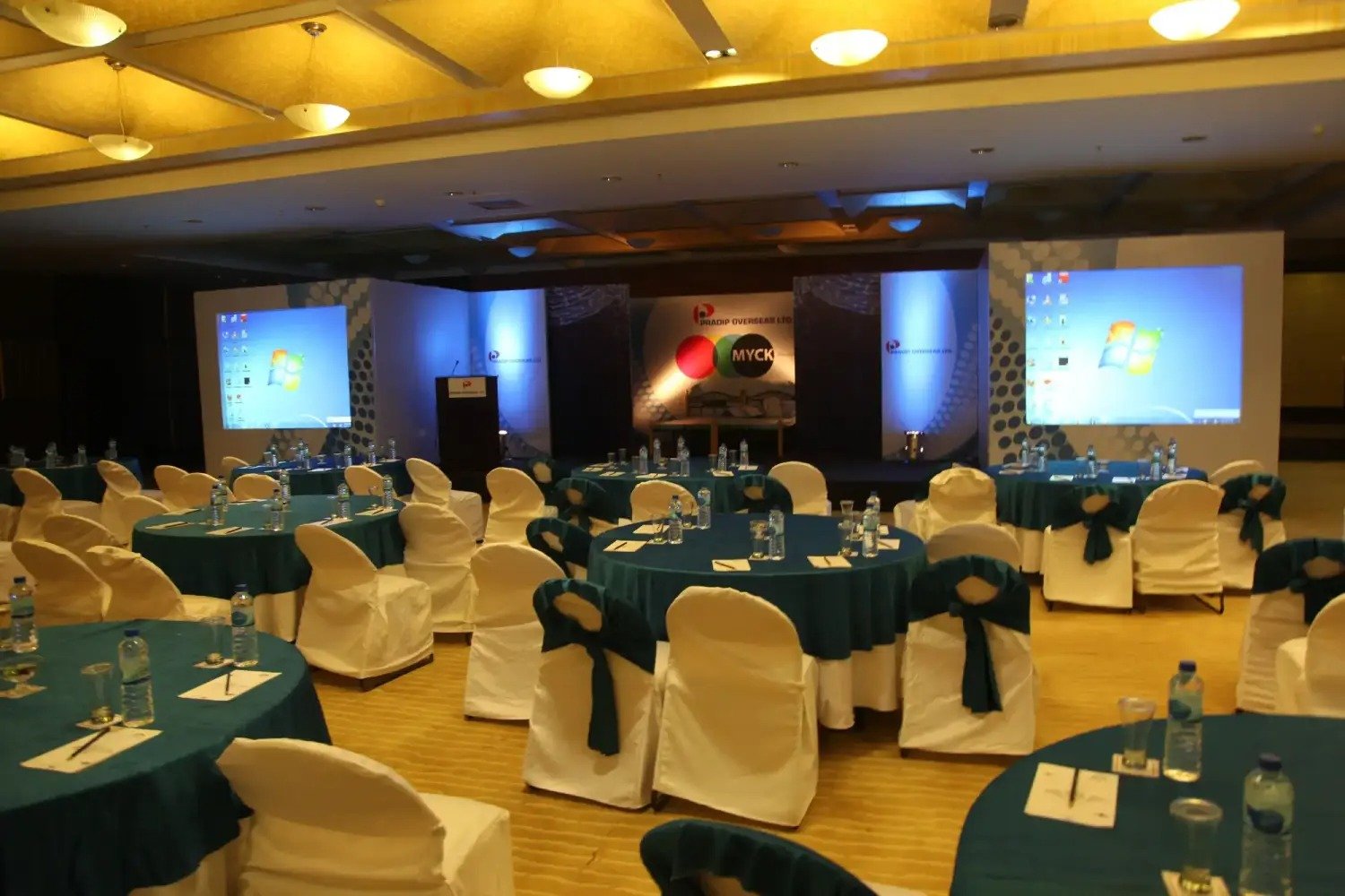 Man and woman speaking on stage at night with blue lighting
